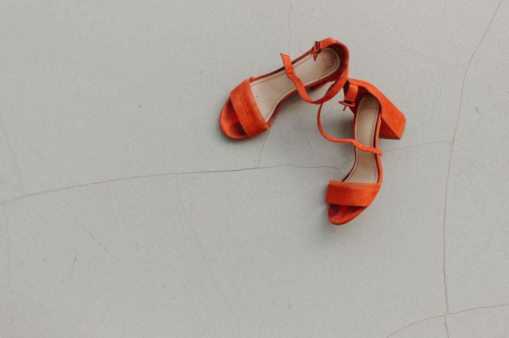 Stylish red high heels placed on a neutral surface, perfect for fashion and lifestyle content
